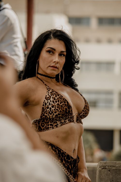 Free Confident woman wearing a leopard print outfit poses outdoors on a sunny day. Stock Photo
