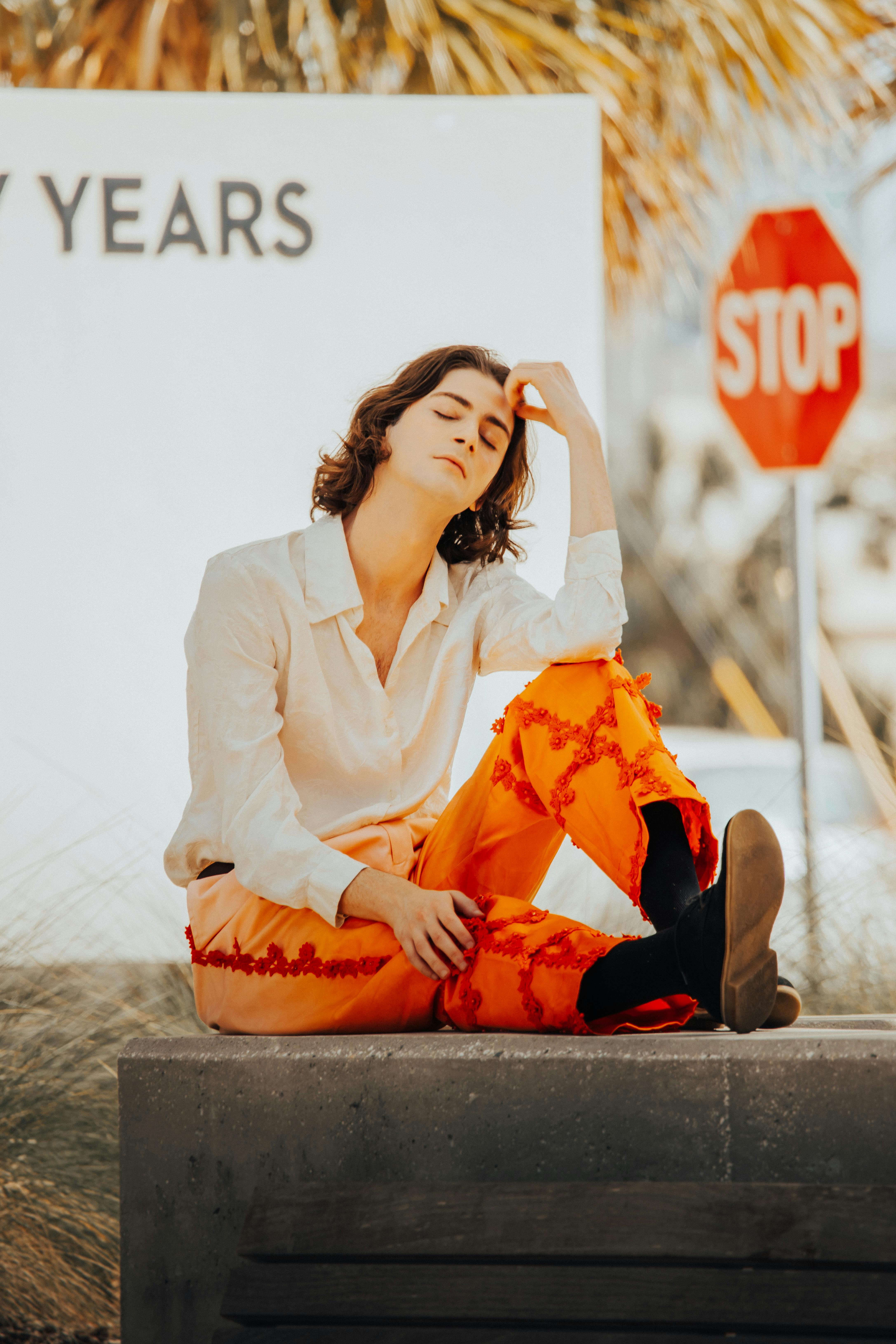 A woman sitting on a bench with her hands on her head