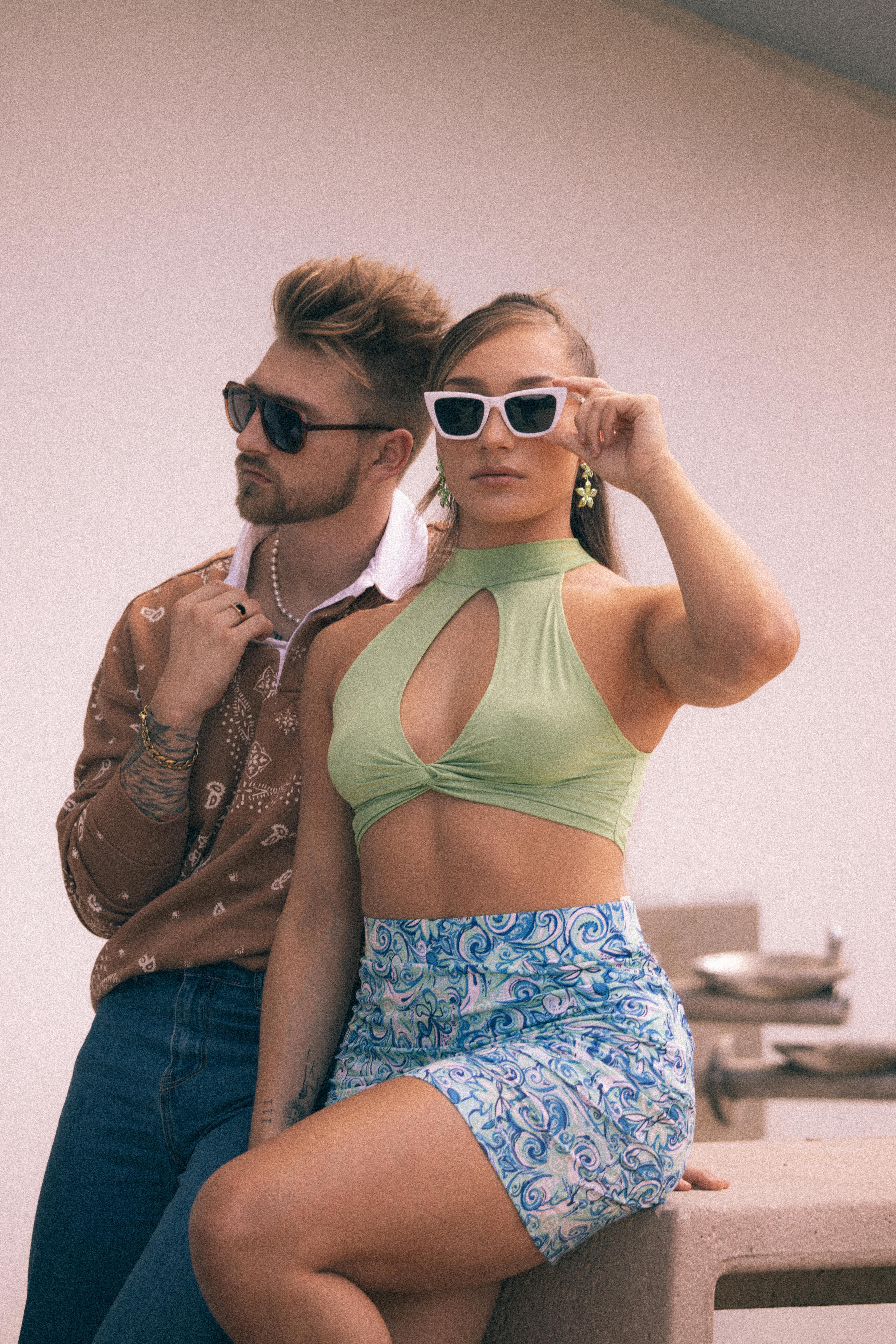 Stylish couple wearing vintage outfits and sunglasses, showcasing retro fashion trends in Tampa.