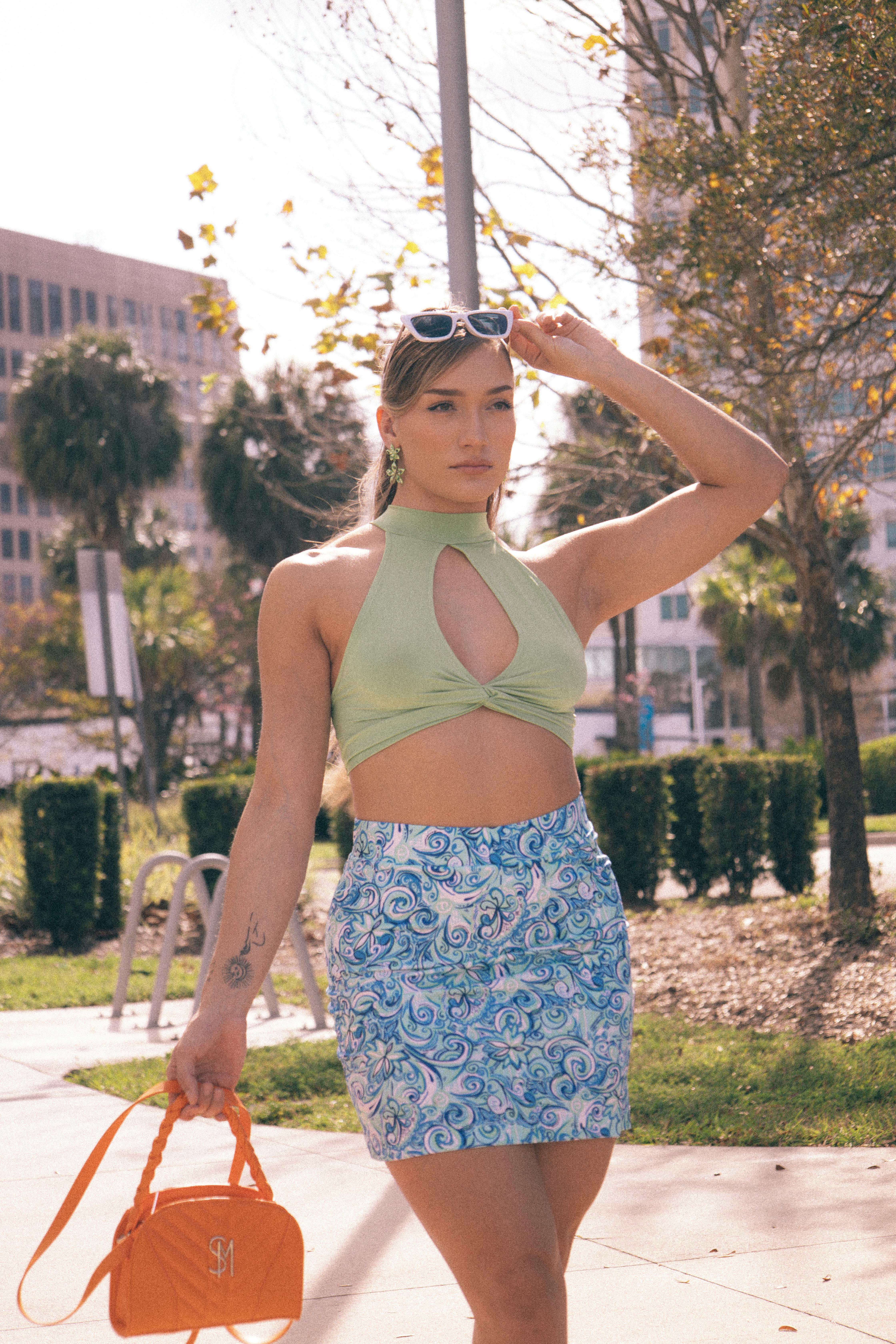 a woman in a green top and blue skirt