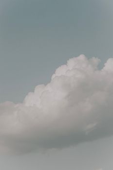 A tranquil scene of white fluffy clouds against a clear blue sky, perfect for nature themes.