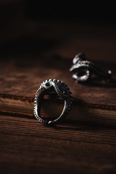 Close-up of a silver octopus-themed ring on a rustic wooden surface, perfect for jewelry enthusiasts.