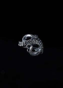 Silver octopus tentacle ring showcased in a studio setting against a black background.