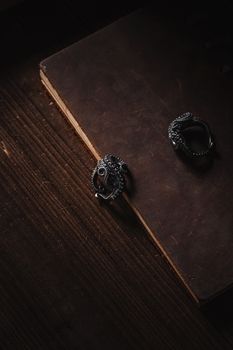 Detailed octopus tentacle ring displayed on an old book, set against a dark wooden background.