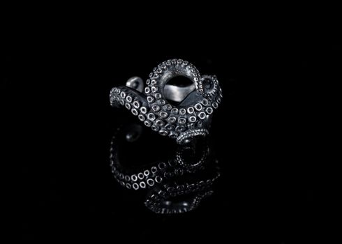 Artistic silver tentacle ring with dark oxidized finish, studio shot on black.