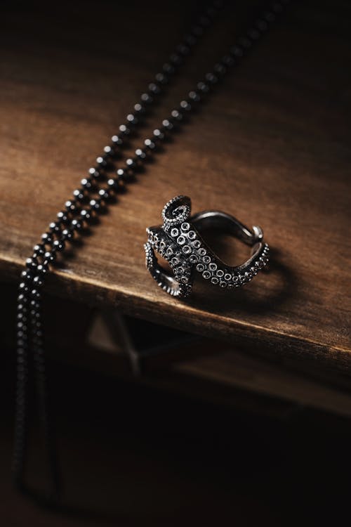 Oxidized Ring and a Pendant on a Wooden Table