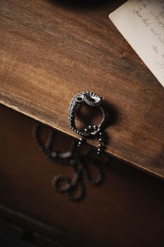 Close-up of an artistic octopus tentacle ring on a textured wooden surface.