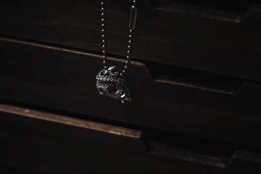 A detailed silver octopus jewelry piece casting shadows against a dark background.