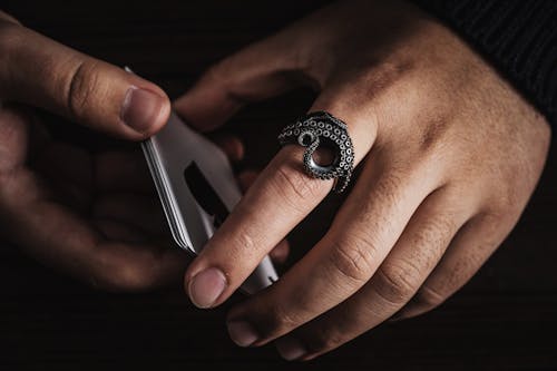 Close-up of Man Wearing an Octopus Tentacle Ring and Holding Cards