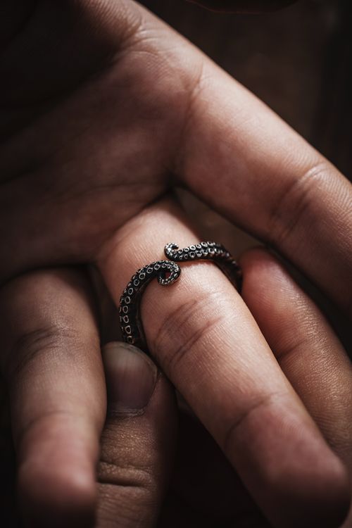 Free Close-up of an oxidized silver octopus tentacle ring on finger, showcasing intricate tentacle design. Stock Photo