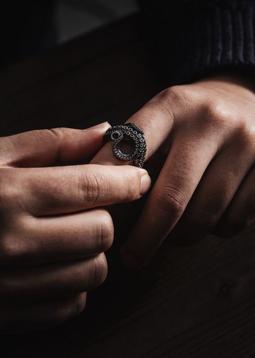 Free A detailed shot of a person adjusting a silver ring, highlighting elegance. Stock Photo