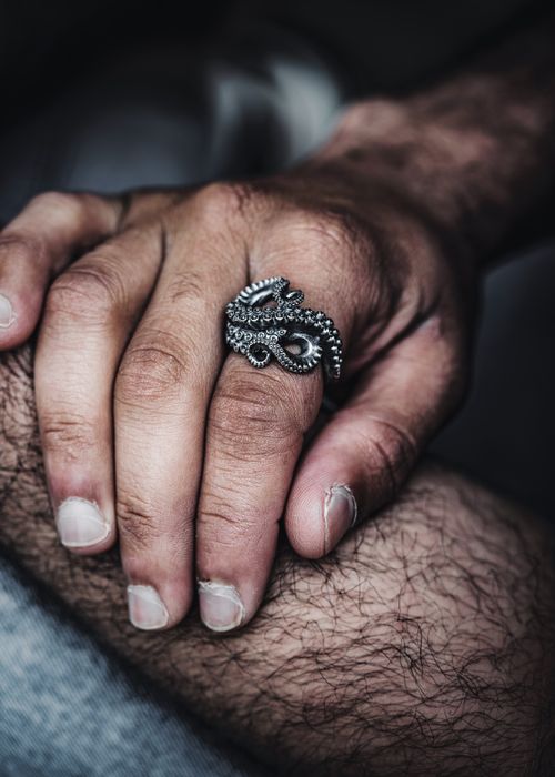 Free Close-up of a hand adorned with a detailed octopus tentacle ring, showcasing metalwork artistry. Stock Photo