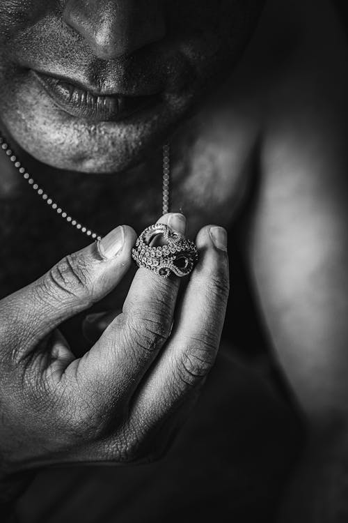 Man Holding an Octopus Ring in Black and White 