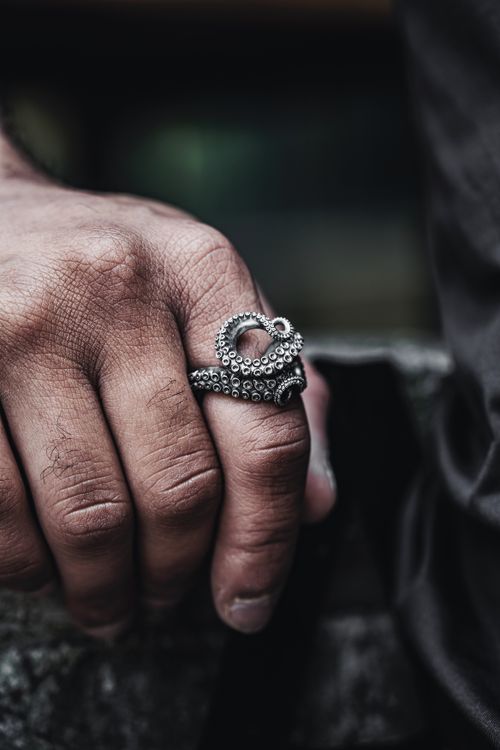 Free Detailed close-up shot of a man's hand wearing a silver octopus ring, showcasing intricate jewelry design. Stock Photo