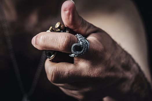 Intriguing close-up of a hand wearing an octopus-shaped ring with other jewelry pieces.