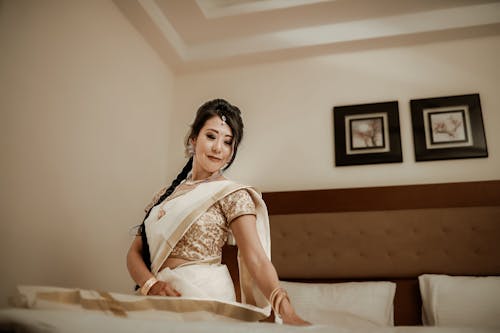 Woman Posing in Traditional Clothing on Bed
