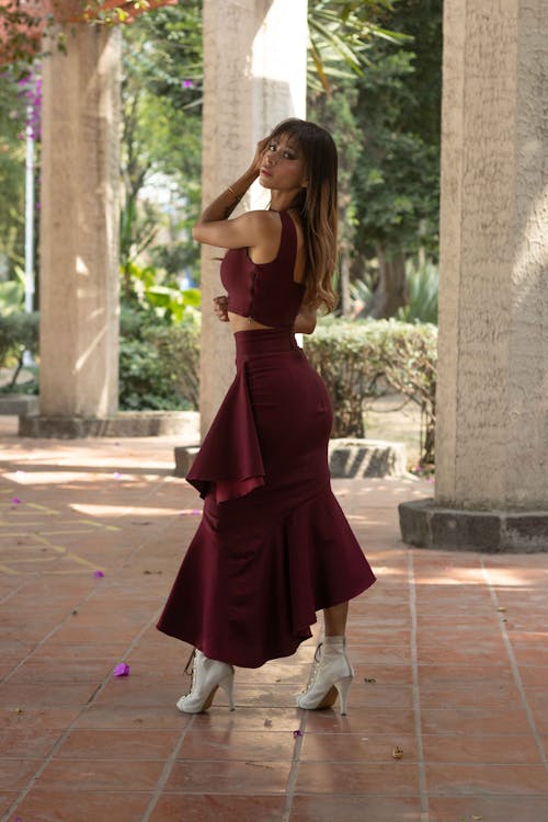 Elegant Woman in a Dress and Heels Standing near Columns 