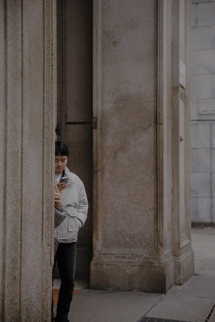 Man Standing By Building Columns