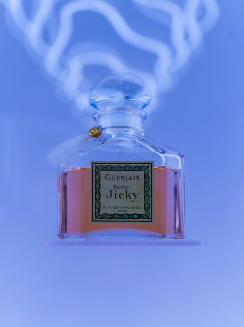 Free Elegant vintage Guerlain Jicky perfume bottle with classic design on a soft blue background. Stock Photo