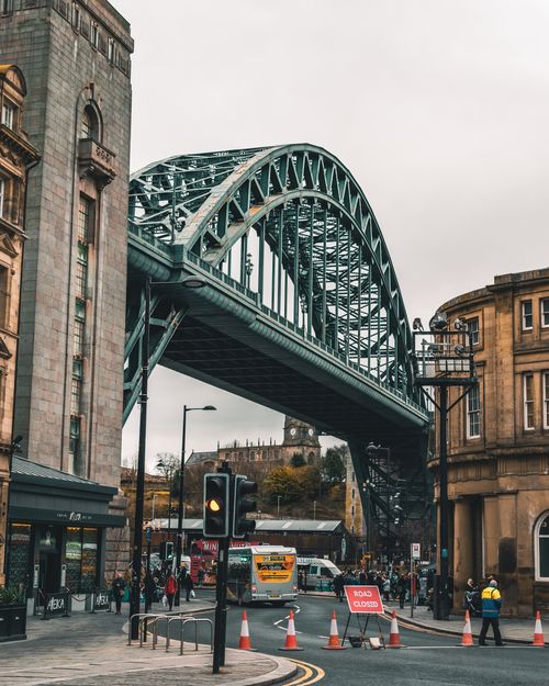 Free Dynamic urban scene featuring the Tyne Bridge, Newcastle upon Tyne, showcasing local architecture and bustling street life. Stock Photo