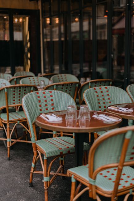 Elegant Parisian outdoor seating with wicker chairs and tables at a stylish cafe.