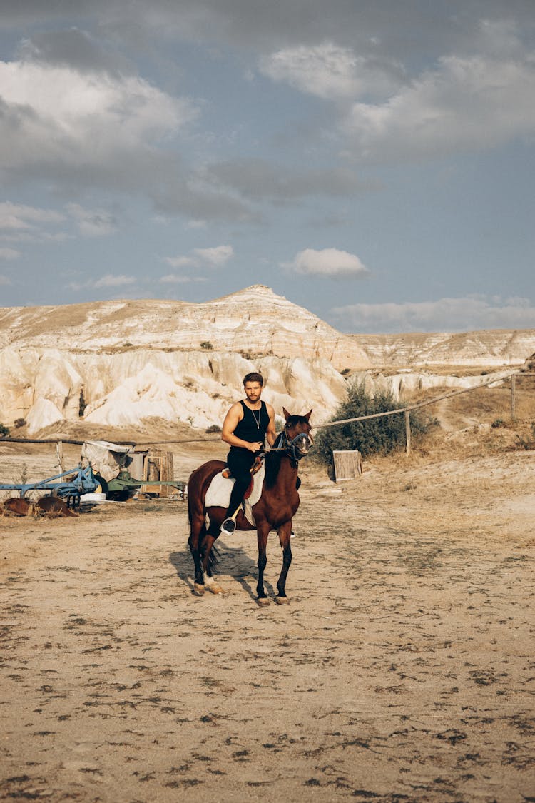 Young Man Riding Horse In Desert