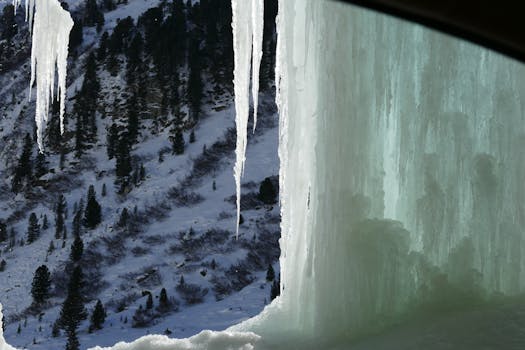 Stunning view of a frozen waterfall set against a snowy mountain landscape in Kühtai, Tirol, Austria.