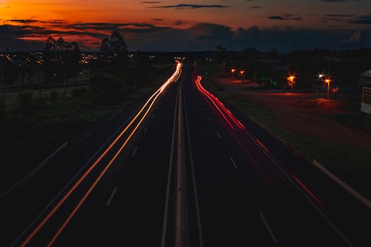 Captivating long exposure of highway traffic trails at sunset, showcasing urban nightlife.