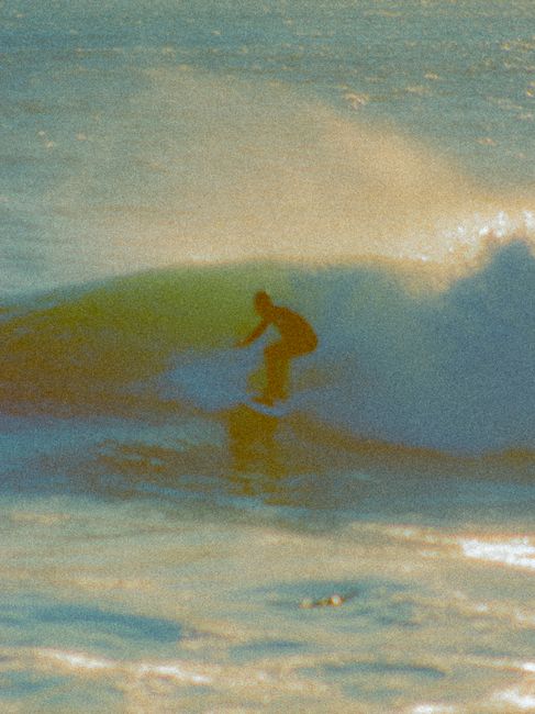 A surfer skillfully navigates a wave, showcasing the art of surfing at sea.