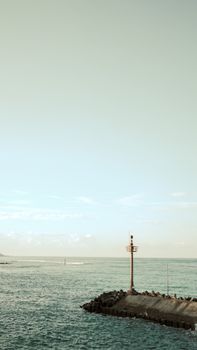 Peaceful scene of a lighthouse on a pier by the sea in Gorontalo, Indonesia.