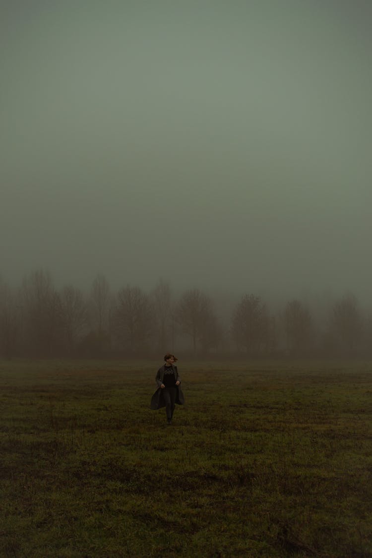 Woman Running On A Foggy Field 