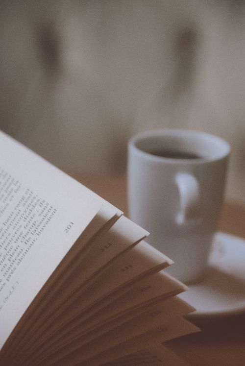 Free A cozy setup featuring an open book and a steaming mug of coffee, perfect for relaxation. Stock Photo