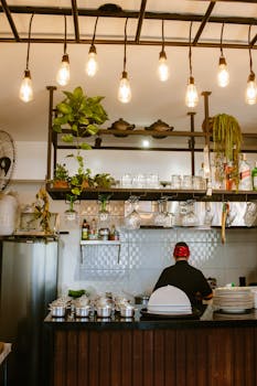 Stylish restaurant interior featuring a chef preparing dishes behind a counter.