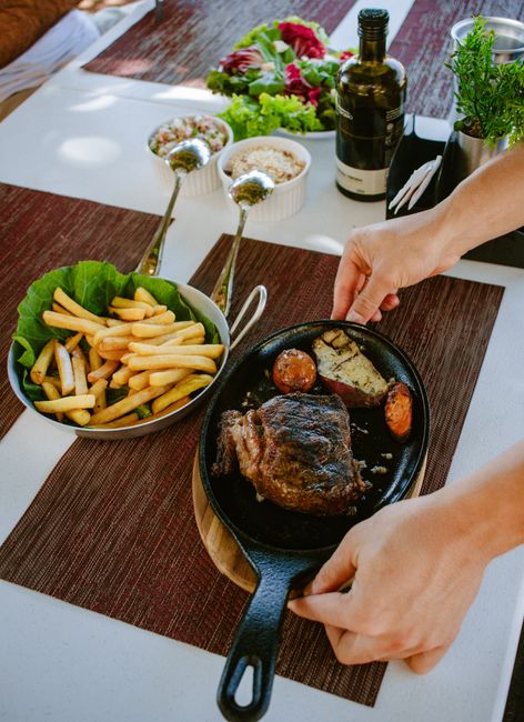 A homemade meal featuring grilled steak, french fries, and fresh salad on a dining table.