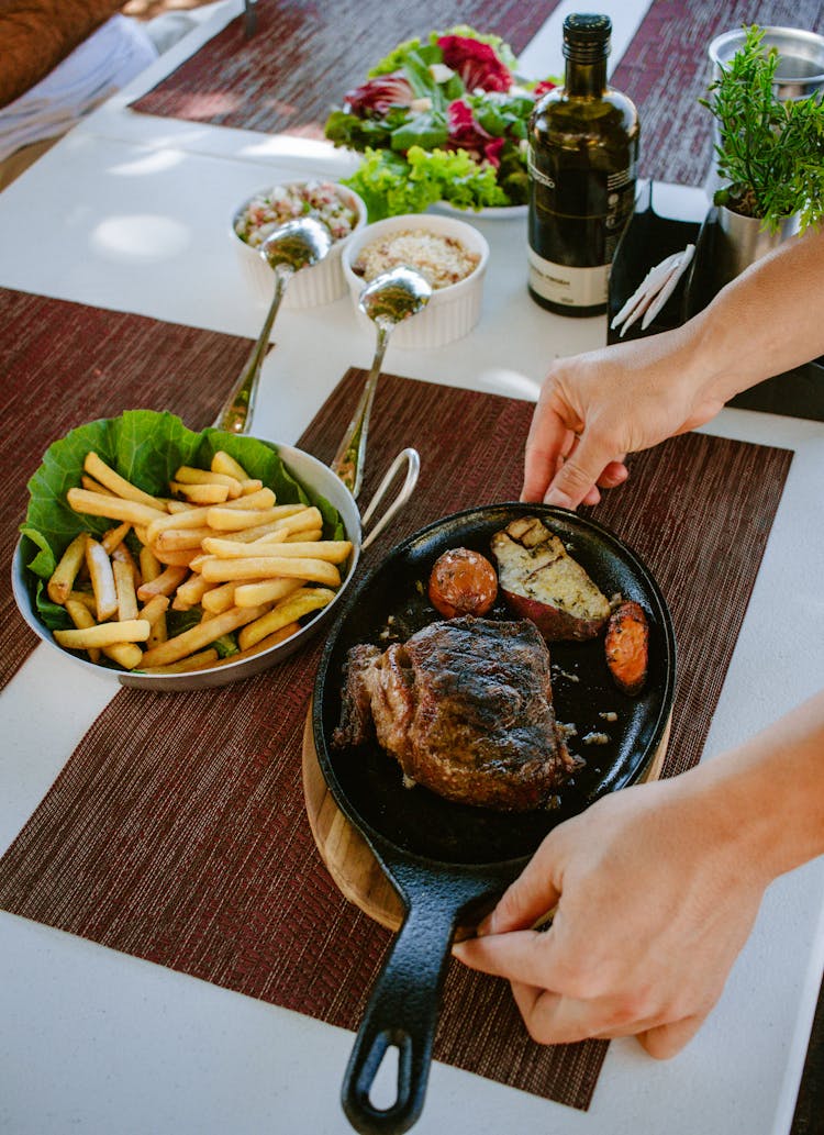 Woman Putting A Meat Dish On A Table 