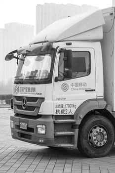 Monochrome image of a logistics truck parked in an urban area, showcasing transportation essentials.