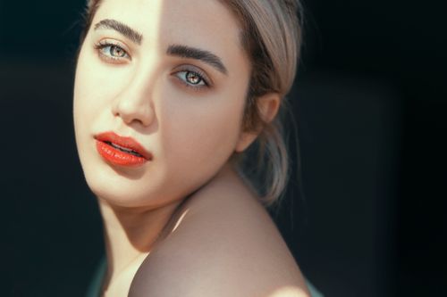 Free Close-up portrait of a young woman with blonde hair and red lips, softly lit. Stock Photo