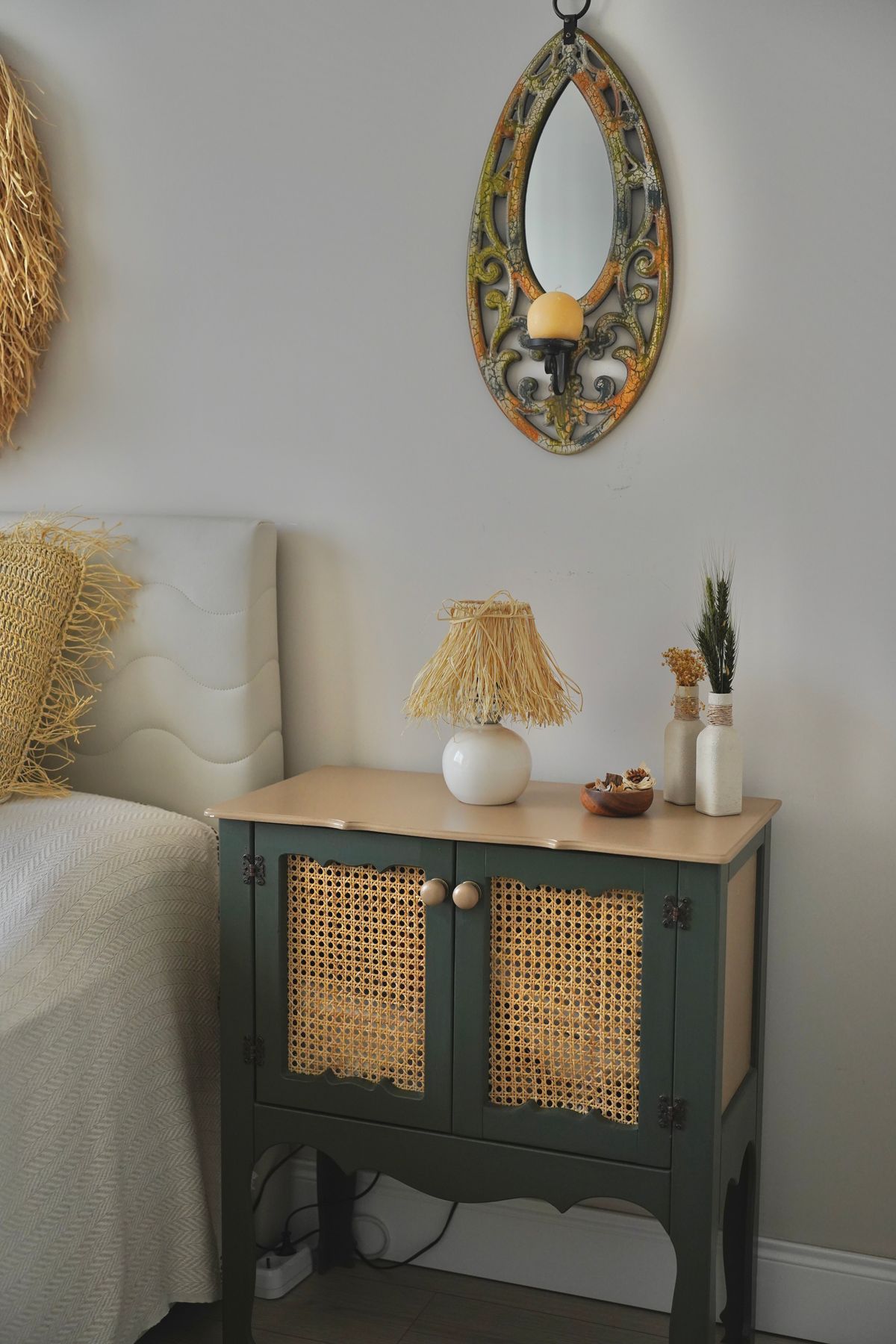 Stylish bedroom with bedside table, mirror, lamp, rug and decorative accents