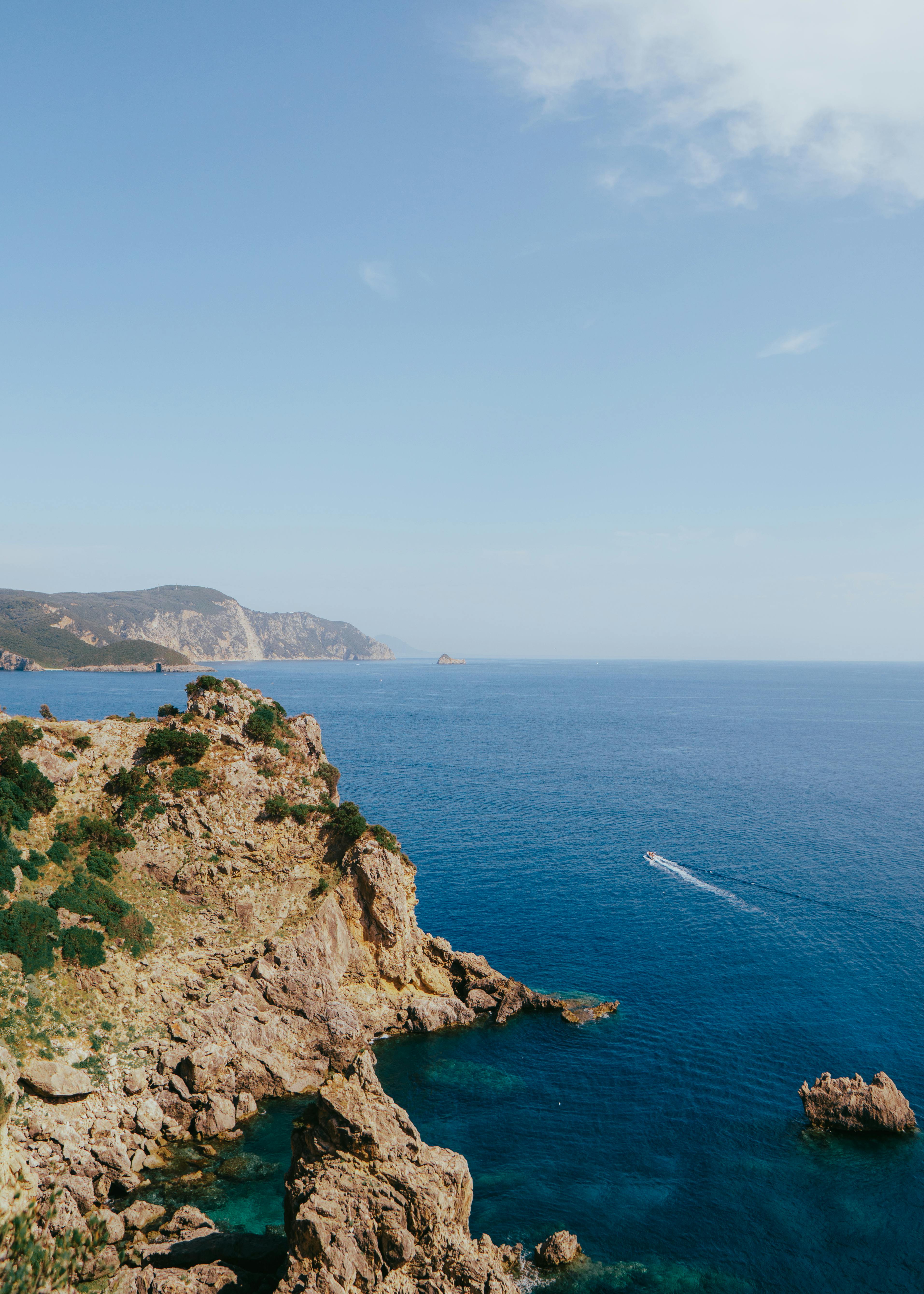Stunning view of rocky cliffs and blue sea along Corfu's coast, Greece.