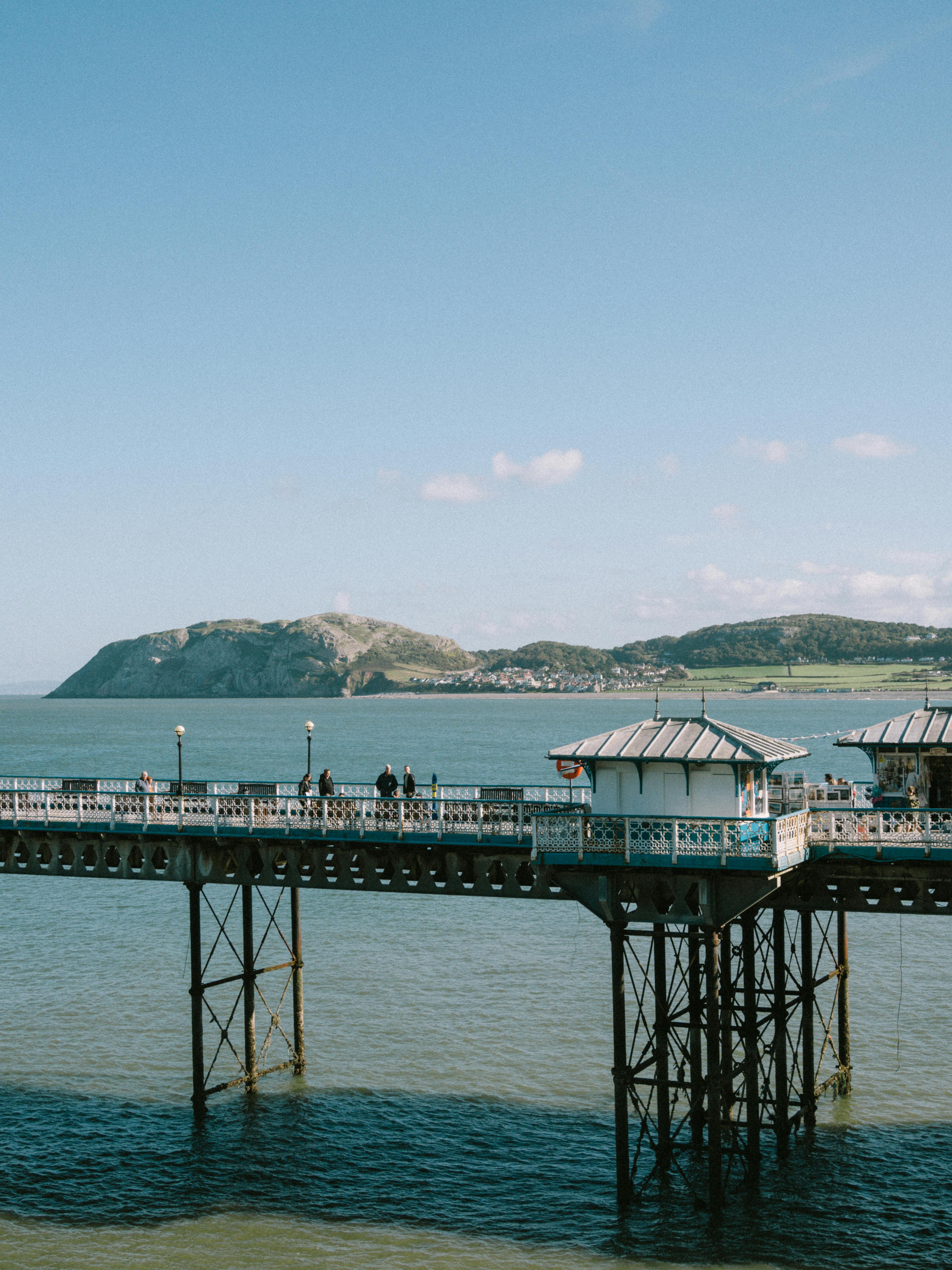 Beautiful coastal view of Llandudno Pier overlooking the sea with distant hills in Wales.