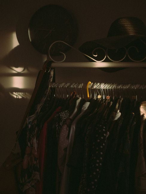 Clothing rack with stylish garments lit softly, creating a warm, intimate interior aesthetic.