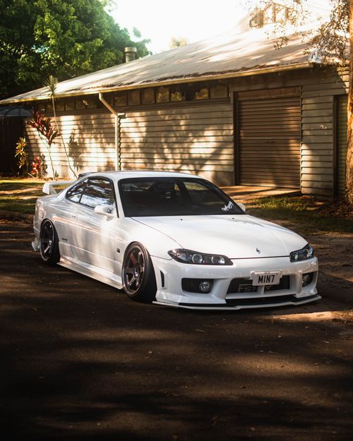 Free A sleek white sports car parked in a sunlit urban neighborhood with a modern exterior. Stock Photo