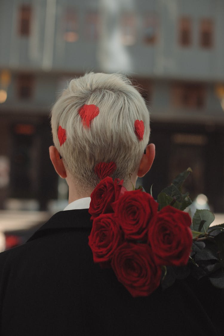 Man With Flowers And Hearts In Hair On City Street