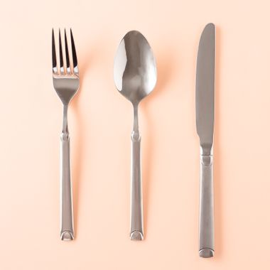 Fork, spoon and knife on a pastel peach background — photo by Amel Uzunovic on Pexels