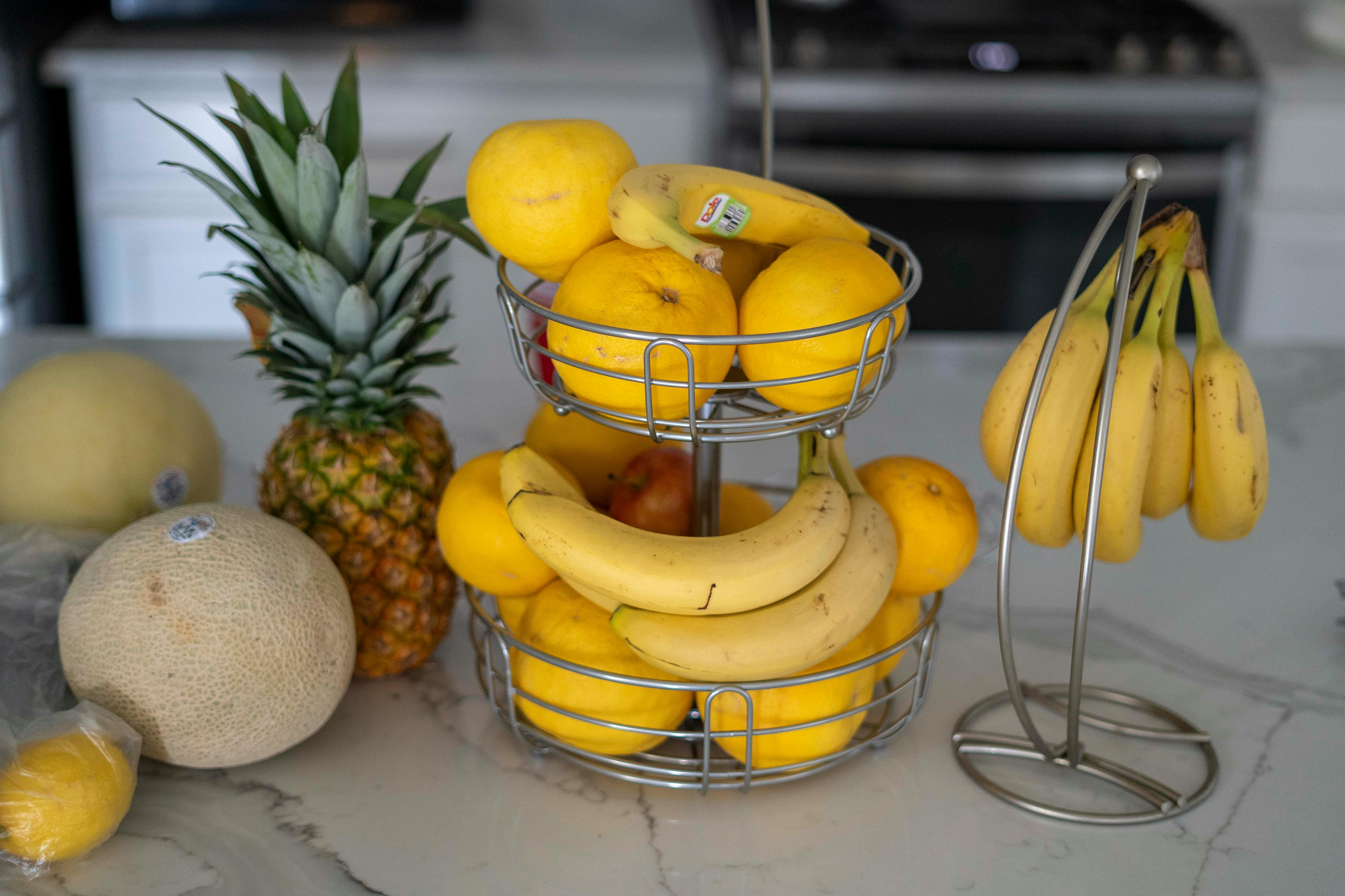 Close‑up of tiny fruit flies hovering near a bowl of fruit
