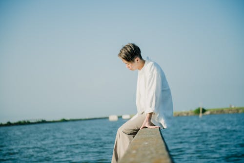 A Young Man Sitting by the Lake