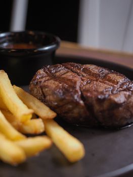 Close-up of a juicy steak with golden French fries on a plate, perfect for a gourmet meal setting.