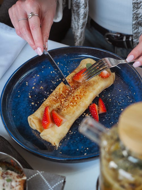 Free Woman Eating Crepes with Strawberries Stock Photo