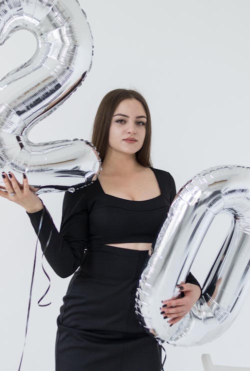 Young Woman Holding Silver Number Balloons