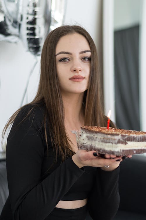 Young Brunette Holding a Small Birthday Cake 